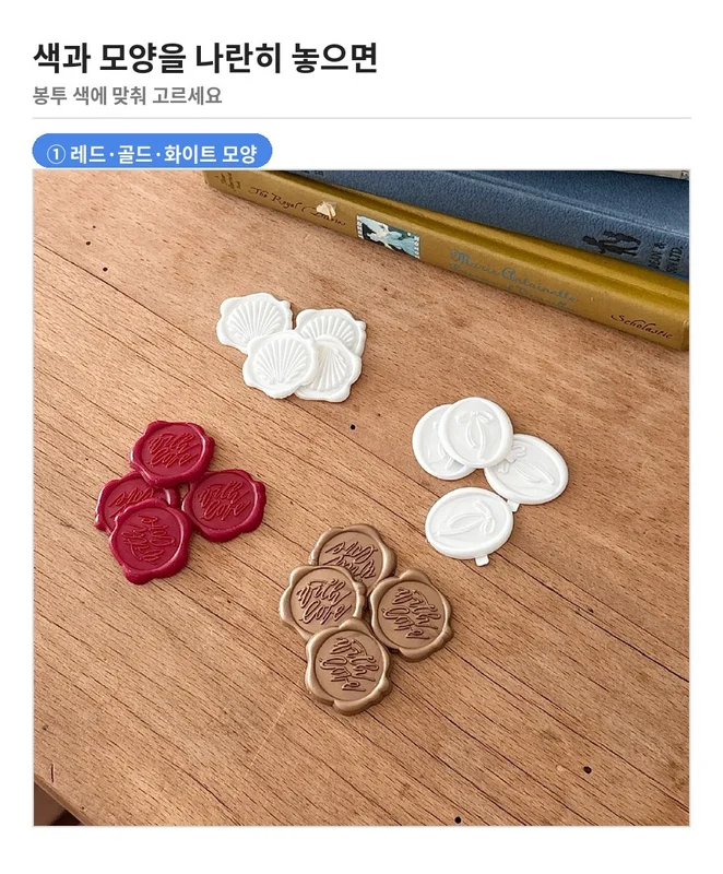 레드, 골드, 화이트 모양 봉인 스티커를 나무 테이블 위에 나란히 놓은 사진